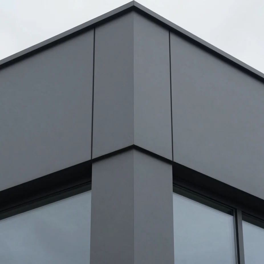 Tight detail crop on a material join of a modern building, showing precision and durability, cool graphite and steel ton